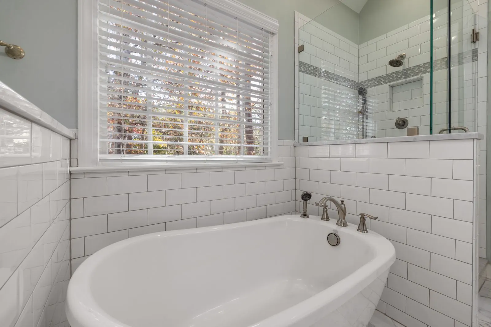 Bathroom with a soaking tub, subway tile and a window