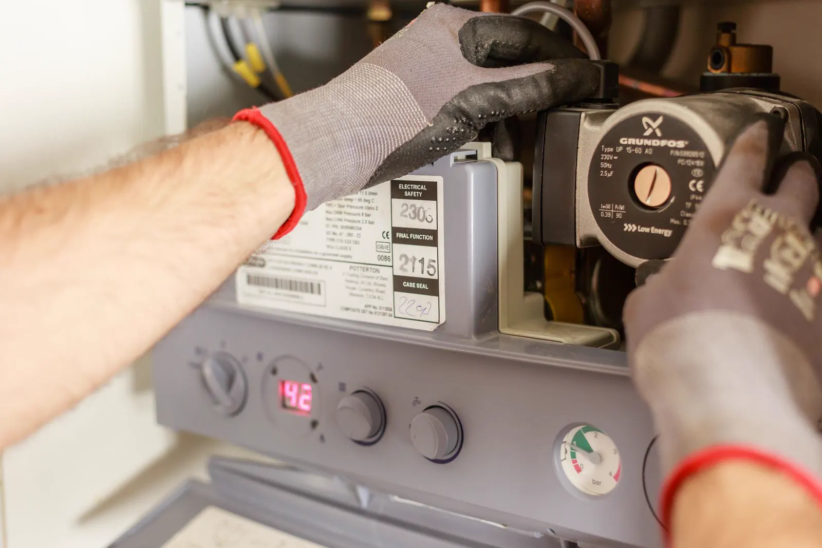 Technician adjusting the pump on a home water heating system