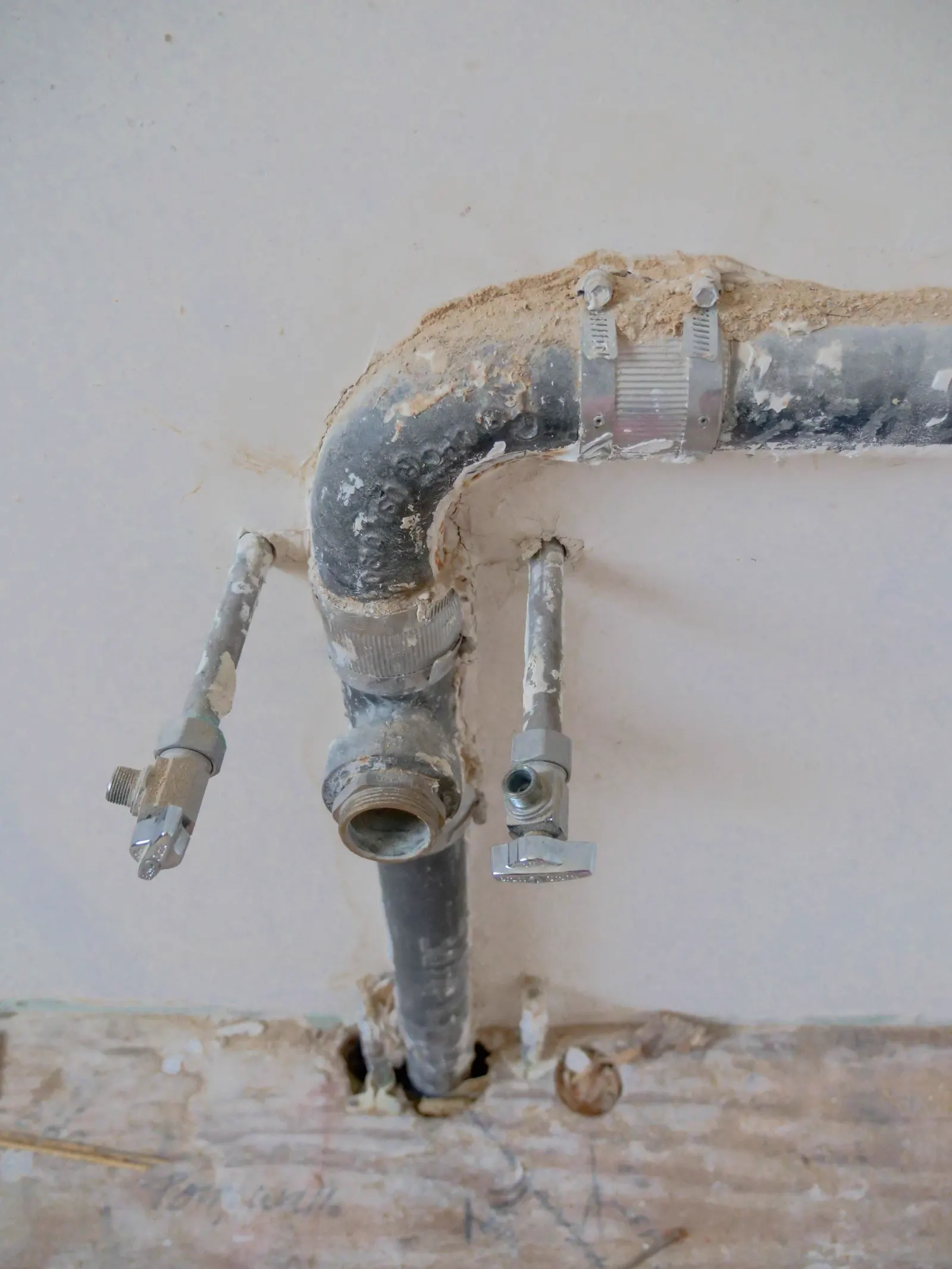 Drain and supply pipes coming out of a wall